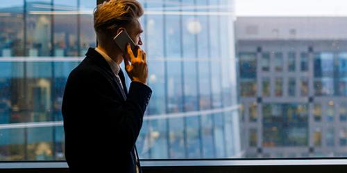 Promoción Oportunidades - Hombre de traje hablando por teléfono en la oficina Promoción Oportunidades - Hombre de traje hablando por teléfono en la oficina